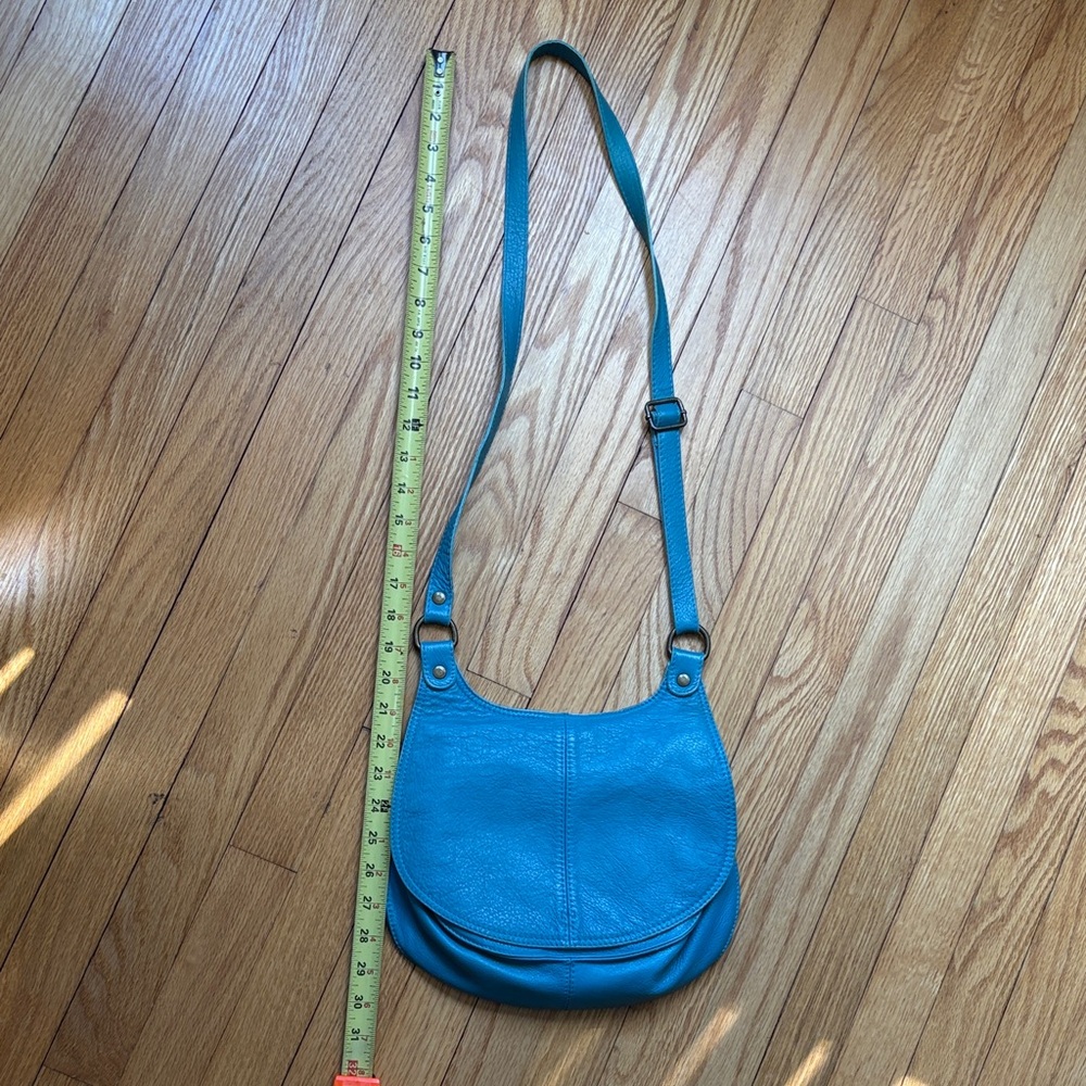 Blue Leather Shoulder Bag with magnetic closure with two zipped pockets.